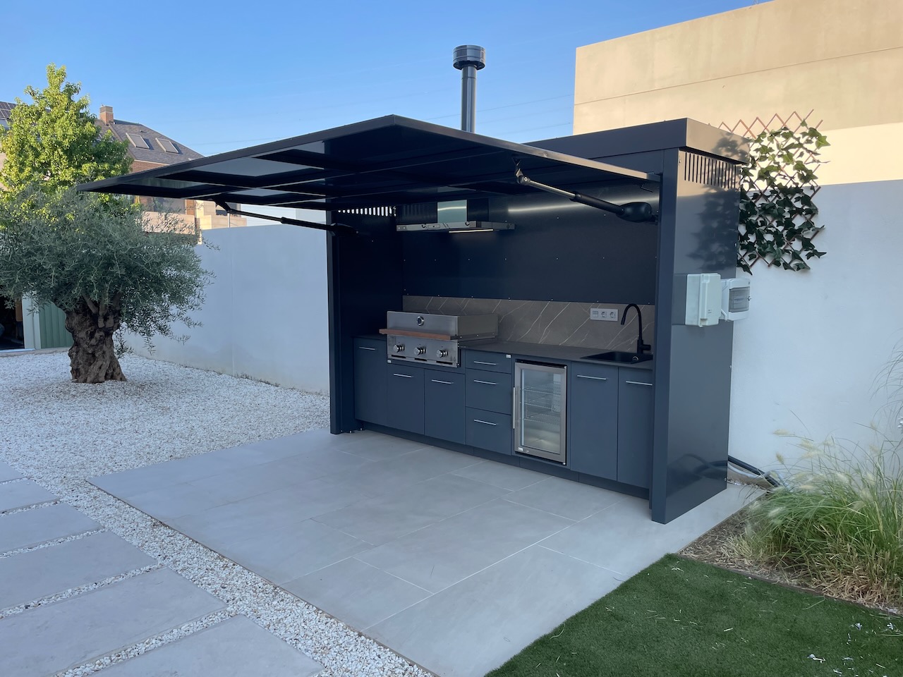 Cucina esterna con copertura apribile, barbecue e cantina vini in giardino privato